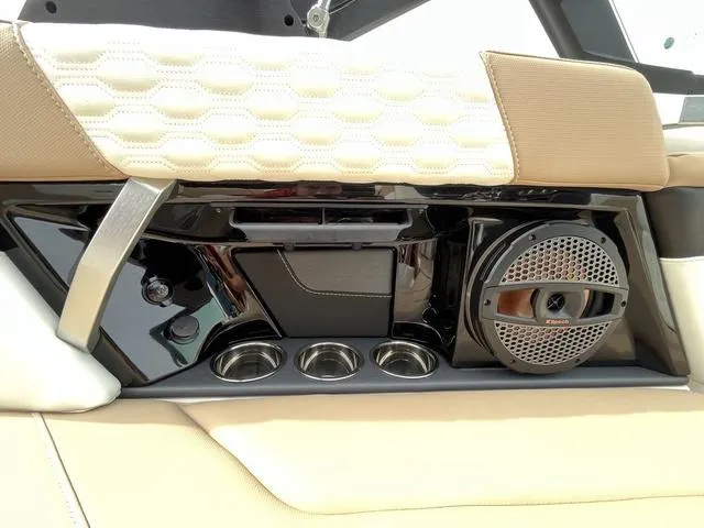 Slide: The Image of 2024 MasterCraft XT20 interior detail with speaker, cup holders, and beige upholstery. - 24