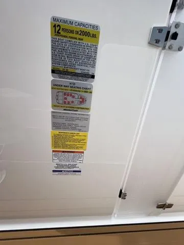 Slide: The Image of 2024 MasterCraft XT20 capacity label, maximum 12 persons or 2000 lbs, safety instructions. - 36