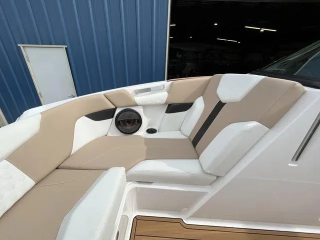 Slide: The Image of 2024 MasterCraft XT20 boat interior with beige and white seating, featuring a speaker and cup holder. - 41