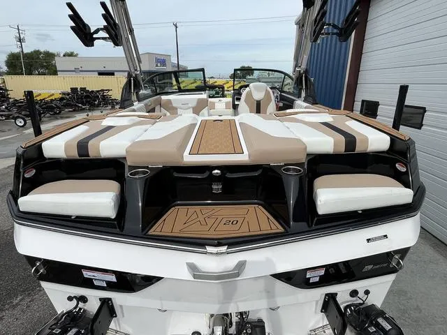 Slide: The Image of 2024 MasterCraft XT20 boat with stylish seating and modern design, docked outdoors. - 8