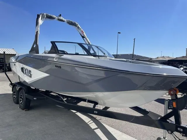 Slide: The Image of 2024 Axis Wake Research T220-R boat on trailer, sleek gray design under clear blue sky. - 4