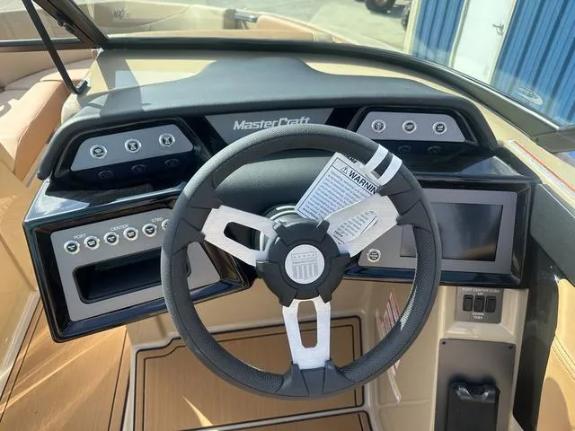 Slide: The Image of 2024 MasterCraft NXT21 boat dashboard with steering wheel and control panel. - 12