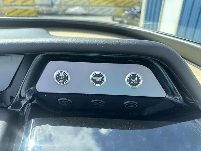 Slide: The Image of Dashboard controls of 2024 MasterCraft NXT21 boat, featuring anchor, courtesy lights, and horn buttons. - 16