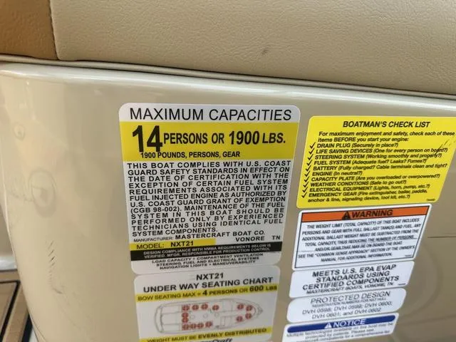 Slide: The Image of 2024 MasterCraft NXT21 capacity label: 14 persons or 1900 lbs, safety compliance details. - 28