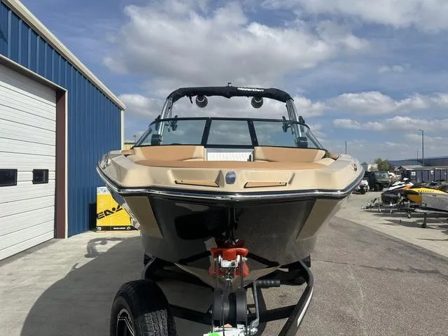 Slide: The Image of 2024 MasterCraft NXT21 boat on trailer, parked outdoors under a partly cloudy sky. - 3