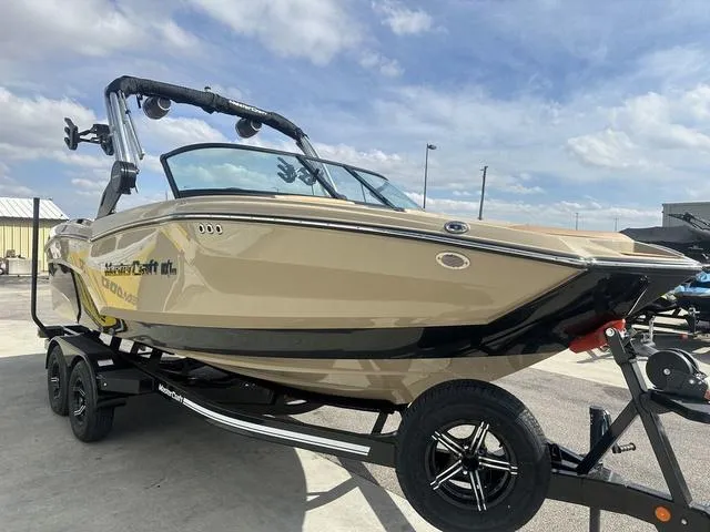 Slide: The Image of 2024 MasterCraft NXT21 boat on trailer under a clear blue sky. - 4