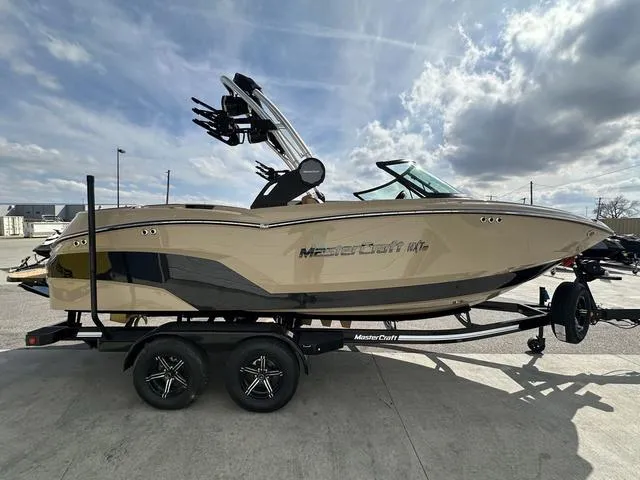 Slide: The Image of 2024 MasterCraft NXT21 boat on trailer under cloudy sky. - 5