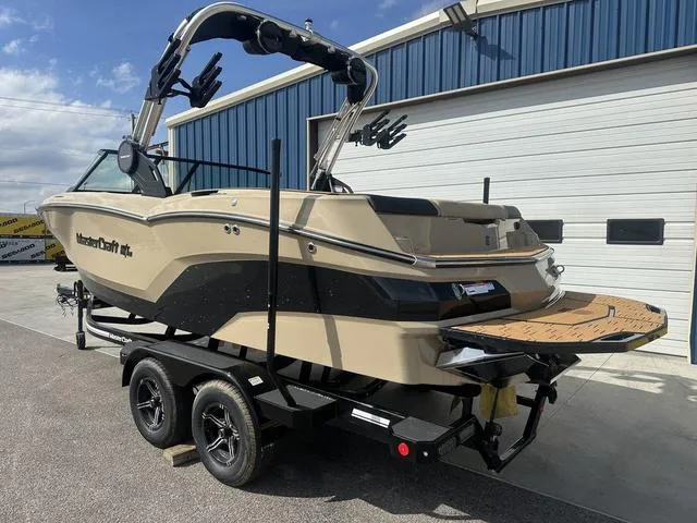 Slide: The Image of 2024 MasterCraft NXT21 boat on trailer, parked outside a blue and white building. - 8