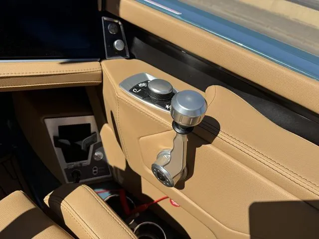 Slide: The Image of 2025 MasterCraft X24 boat interior with tan leather and control panel. - 15