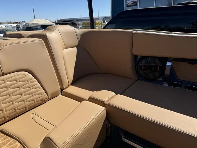 Slide: The Image of 2025 MasterCraft X24 boat interior with tan leather seating and speaker system. - 23