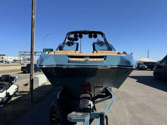 Slide: The Image of 2025 MasterCraft X24 boat on trailer, parked outdoors under clear blue sky. - 3