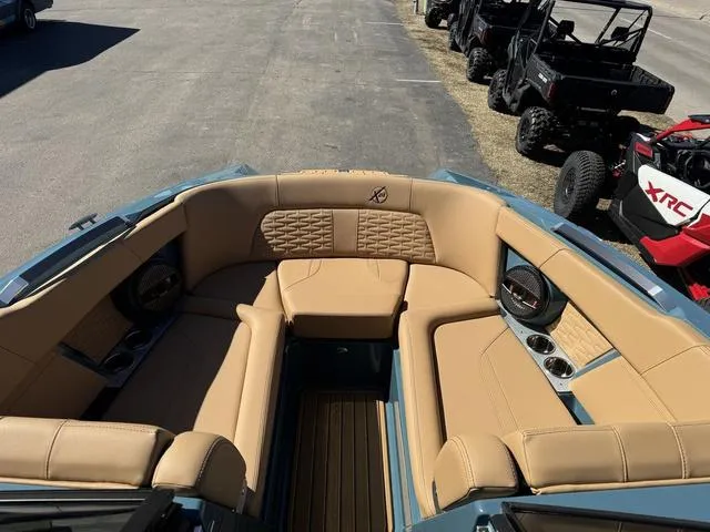 Slide: The Image of 2025 MasterCraft X24 boat interior with tan leather seating and cup holders. - 32
