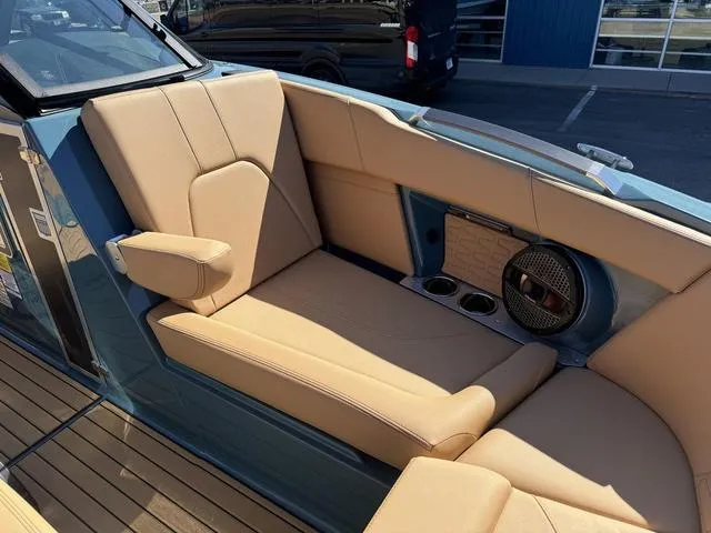 Slide: The Image of 2025 MasterCraft X24 boat interior with tan leather seating and cup holders. - 33