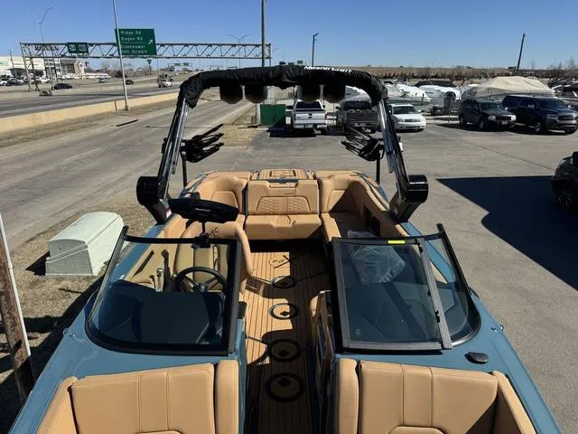 Slide: The Image of 2025 MasterCraft X24 boat with tan interior, parked outdoors on a sunny day. - 36