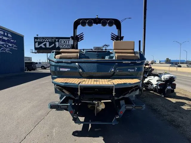 Slide: The Image of 2025 MasterCraft X24 boat with teak deck, parked outdoors on a sunny day. - 6