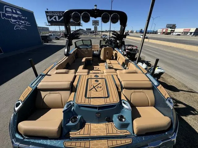 Slide: The Image of 2025 MasterCraft X24 boat with luxurious seating and modern design, parked outdoors. - 8