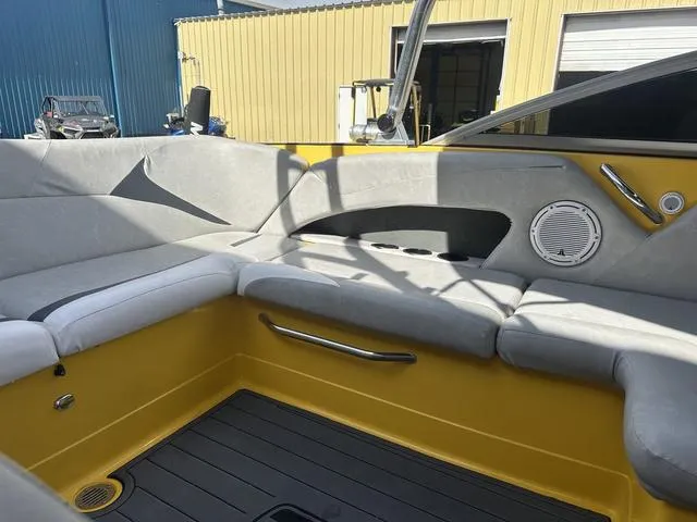 Slide: The Image of 2006 MasterCraft X2 boat interior with yellow and gray seating, speaker, and handle. - 18