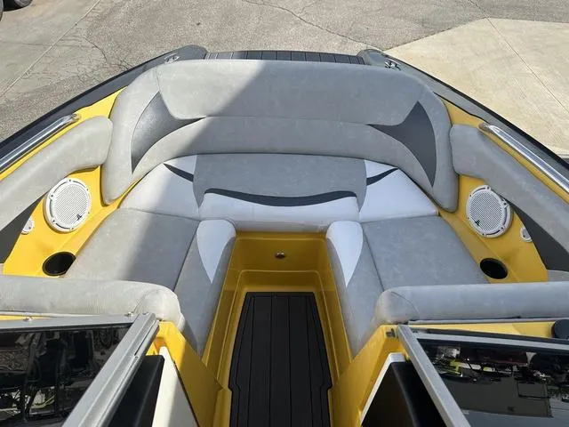 Slide: The Image of 2006 MasterCraft X2 boat interior with gray and yellow seating, featuring built-in speakers. - 22