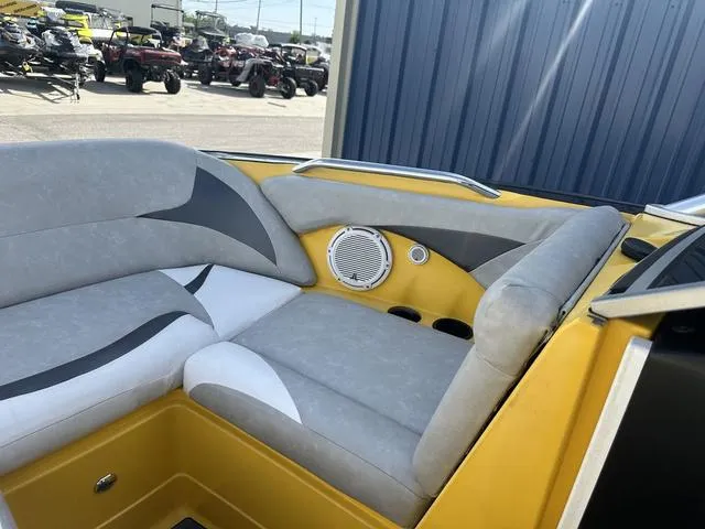 Slide: The Image of 2006 MasterCraft X2 boat interior with gray and yellow seating, speaker, and cup holders. - 24
