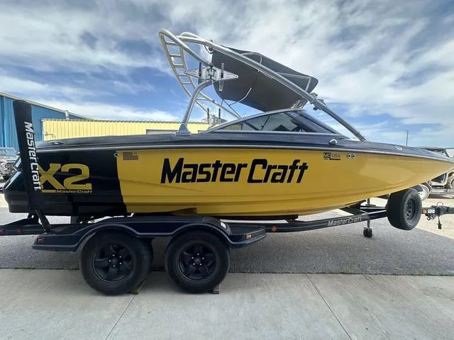 Slide: The Image of 2006 MasterCraft X2 boat in yellow and black on a trailer, under a blue sky. - 5