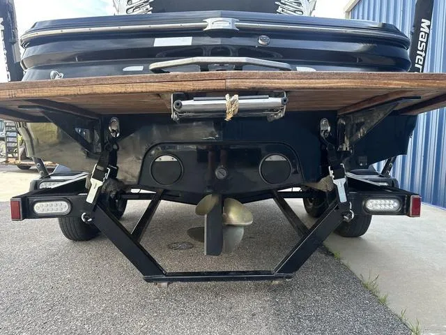 Slide: The Image of 2006 MasterCraft X2 boat rear view showing propeller and trailer on pavement. - 9