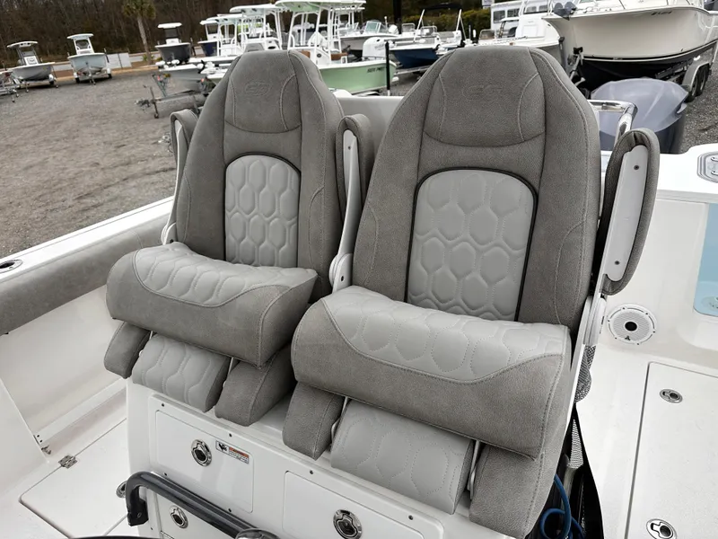 Slide: The Image of 2021 Sea Fox 288 Commander boat seats, gray upholstery, docked with other boats in background. - 9