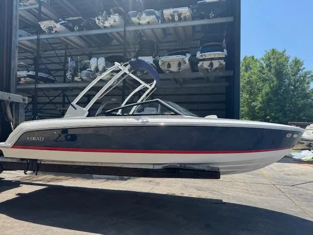 Slide: The Image of 2025 Cobalt CS22 boat in storage facility, side view with blue and white exterior. - 1