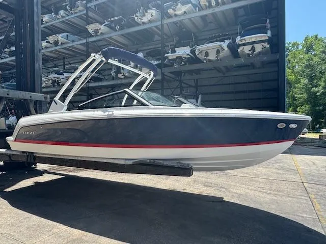 Slide: The Image of 2025 Cobalt CS22 boat in storage facility, side view with blue and white design. - 2