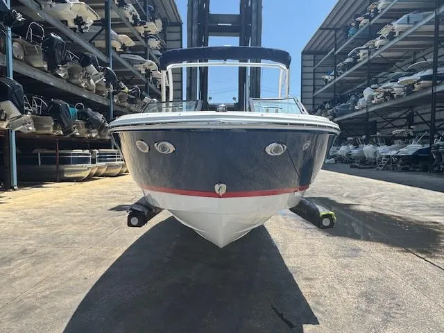 Slide: The Image of 2025 Cobalt CS22 boat in storage facility, front view, blue hull with red stripe. - 8