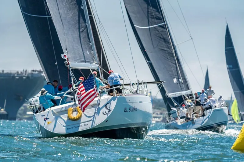 Slide: The Image of Sailboats racing on the water, featuring a 2001 Beneteau First 47.7 with an American flag. - 20