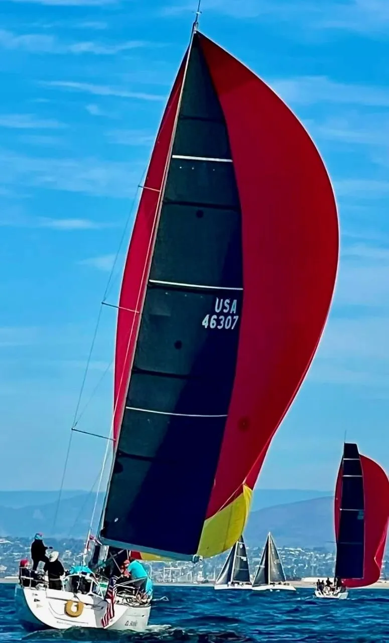 Slide: The Image of Sailing yacht Beneteau First 47.7, 2001, with vibrant red and black spinnaker on open water. - 22