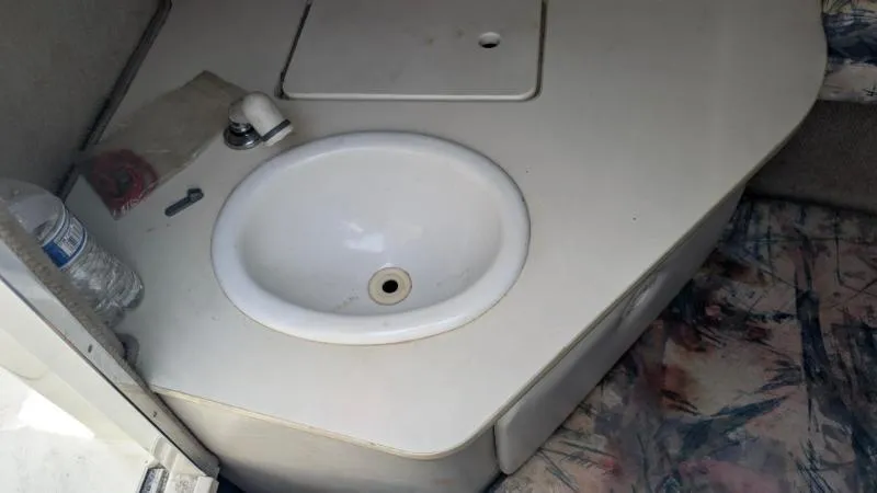 Slide: The Image of 1997 Sea Ray 215 Express Cruiser interior sink area with faucet and countertop. - 11
