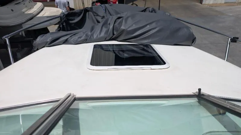Slide: The Image of 1997 Sea Ray 215 Express Cruiser with open hatch, covered deck, and visible windshield. - 14