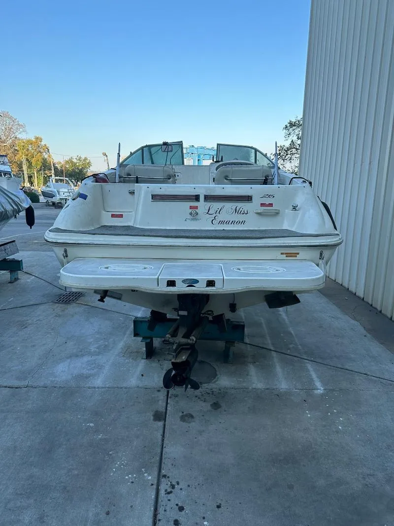 Slide: The Image of 1997 Sea Ray 215 Express Cruiser docked, rear view, white exterior, parked on concrete. - 18