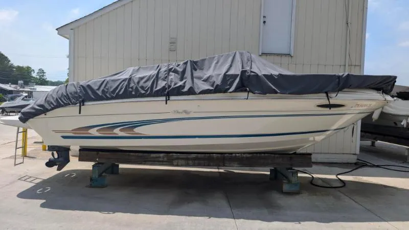 Slide: The Image of 1997 Sea Ray 215 Express Cruiser boat covered and docked outdoors. - 21