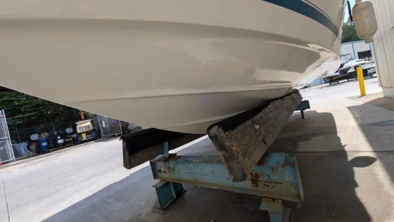 Slide: The Image of 1997 Sea Ray 215 Express Cruiser on a boat lift, showing hull details. - 3