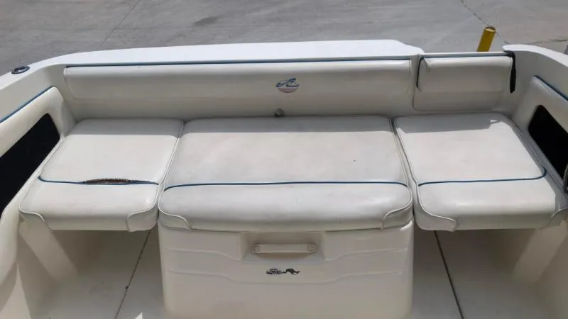 Slide: The Image of 1997 Sea Ray 215 Express Cruiser boat seating area with white upholstery. - 6