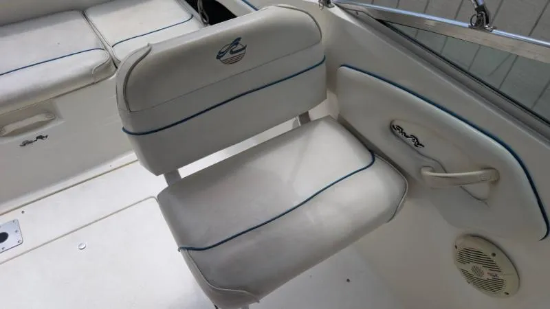 Slide: The Image of 1997 Sea Ray 215 Express Cruiser interior seating with white upholstery and blue accents. - 7