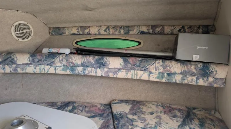 Slide: The Image of Interior cabin of a 1997 Sea Ray 215 Express Cruiser with patterned cushions and a small window. - 9