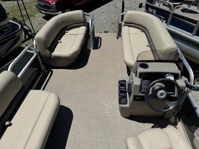 Slide: The Image of 2024 Sun Tracker Party Barge 16 DLX interior with beige seating and steering console. - 46