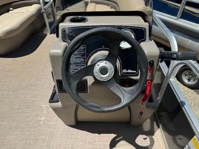 Slide: The Image of 2024 Sun Tracker Party Barge 16 DLX steering console with black wheel and controls. - 47
