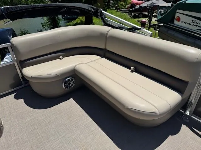 Slide: The Image of 2024 Sun Tracker Party Barge 16 DLX seating area with beige upholstery and speaker. - 49
