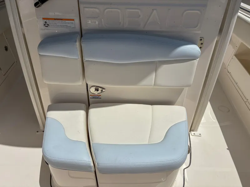 Slide: The Image of 2023 Robalo R302 boat seating with white and blue cushions. - 11