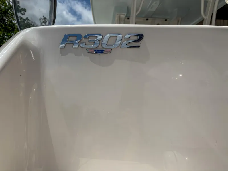 Slide: The Image of 2023 Robalo R302 boat emblem on white surface under clear sky. - 2