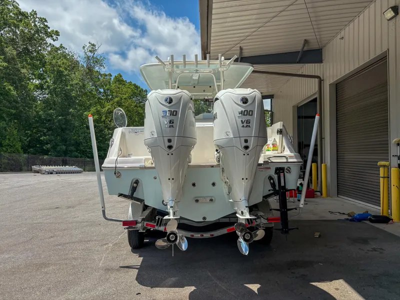 Slide: The Image of 2023 Robalo R302 boat with dual 300 V6 engines, parked outdoors. - 3