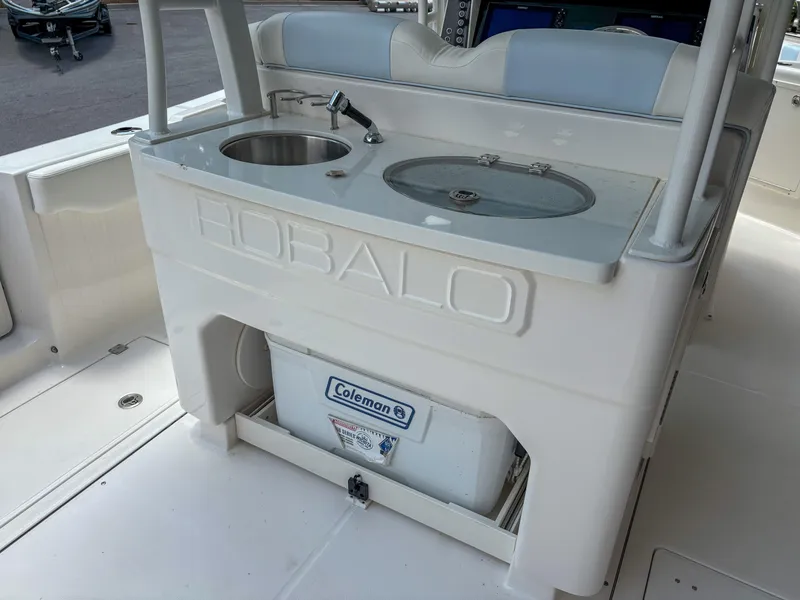 Slide: The Image of 2023 Robalo R302 boat with sink and storage area, featuring Coleman cooler. - 7