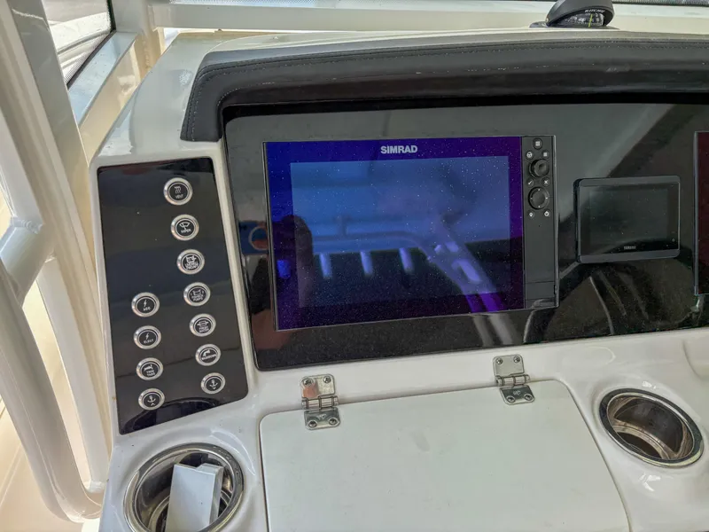 Slide: The Image of 2023 Robalo R302 boat dashboard with Simrad display and control panel. - 9