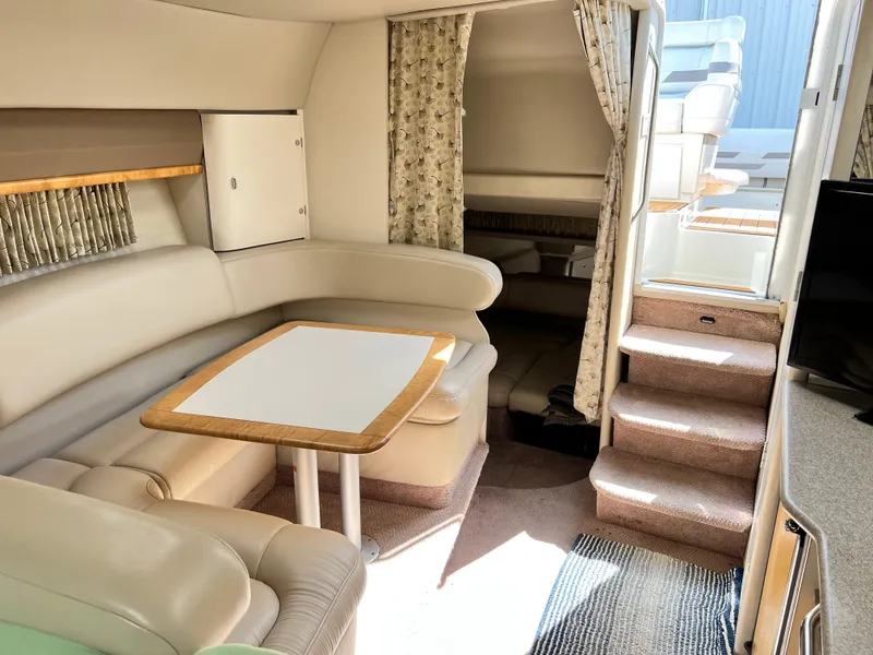 Slide: The Image of 1999 Formula 31 PC yacht interior with beige seating, dining table, and stairs to deck. - 11