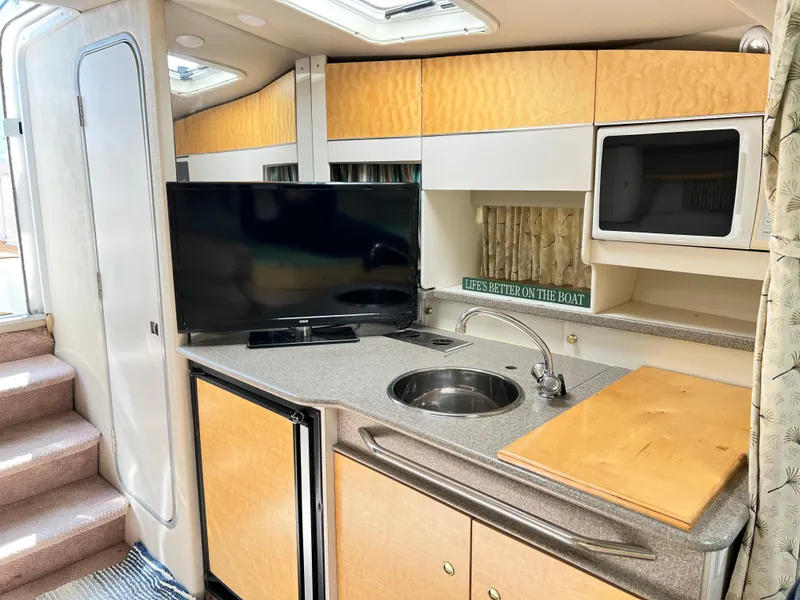 Slide: The Image of 1999 Formula 31 PC yacht interior with kitchenette, TV, and microwave. - 14