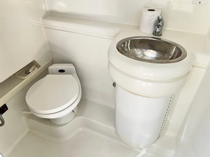 Slide: The Image of 1999 Formula 31 PC boat bathroom with toilet, sink, and toilet paper. - 18